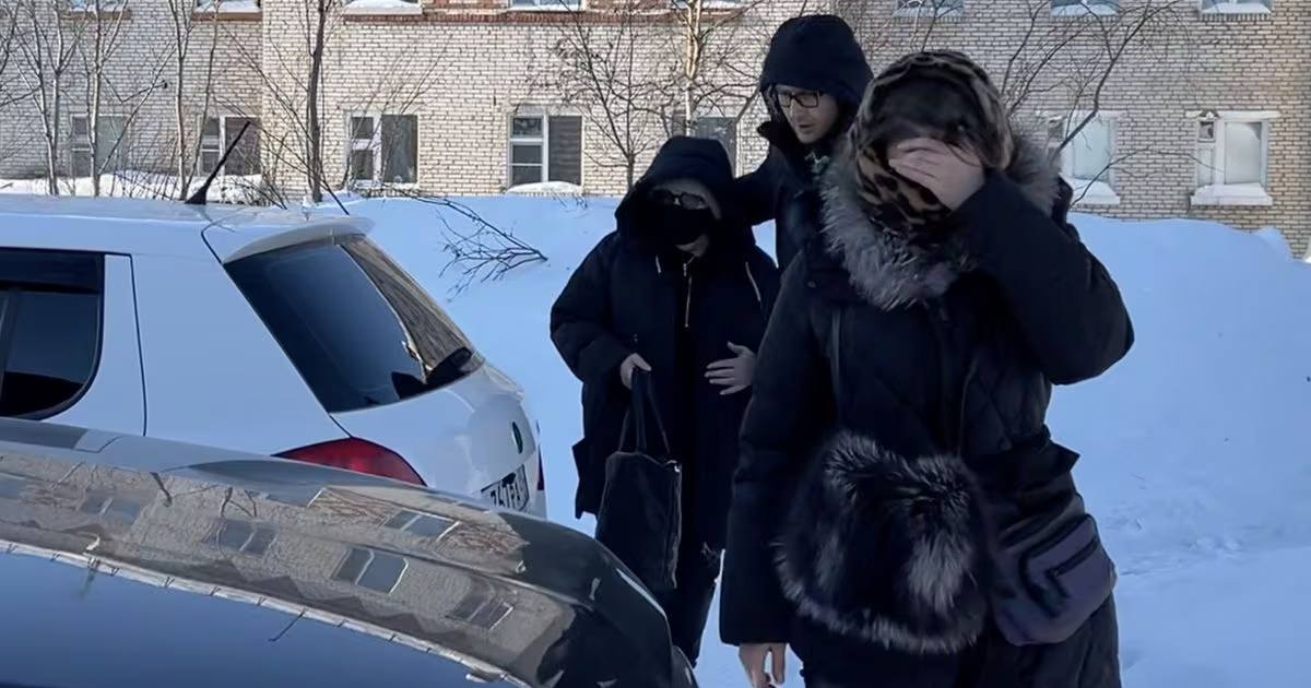 Мать Навального, Людмилу, (на дальнем плане) сопровождают в автомобиль, когда она выезжает из исправительной колонии ИК-3, где отбывал наказание ее сын / Фото Reuters