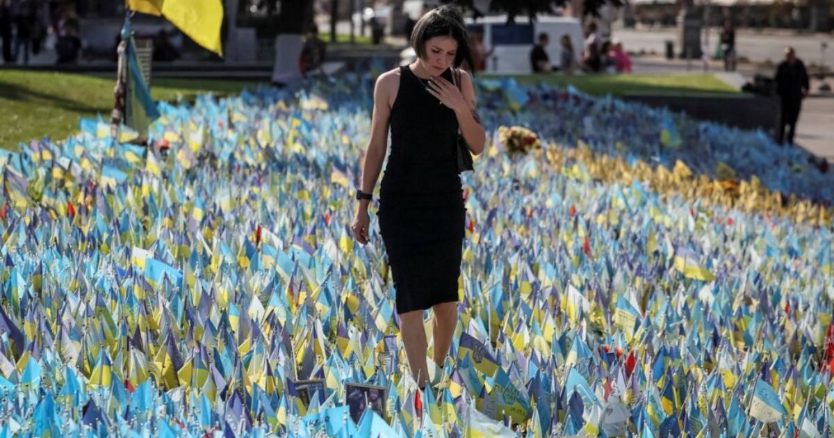 Жінка біля імпровізованого меморіалу з прапорами, на яких нанесені імена загиблих воїнів. Майдан Незалежності в Києві / Фото Reuters