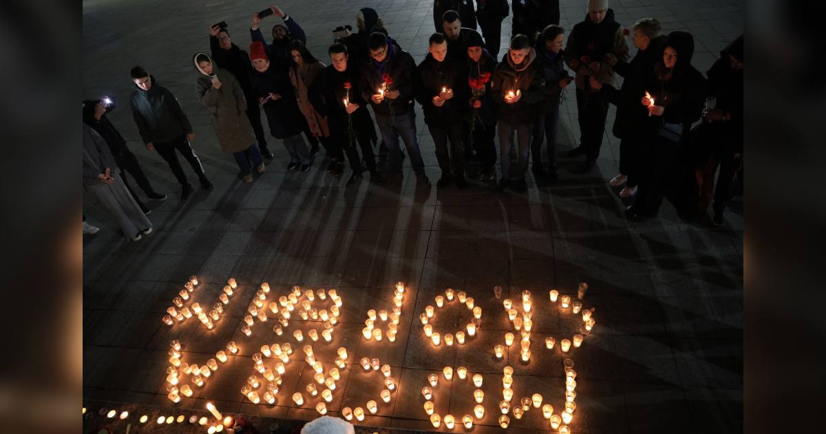 Люди покладають квіти і запалюють свічки в пам'ять про стрілянину на московському концерті / Фото AFP