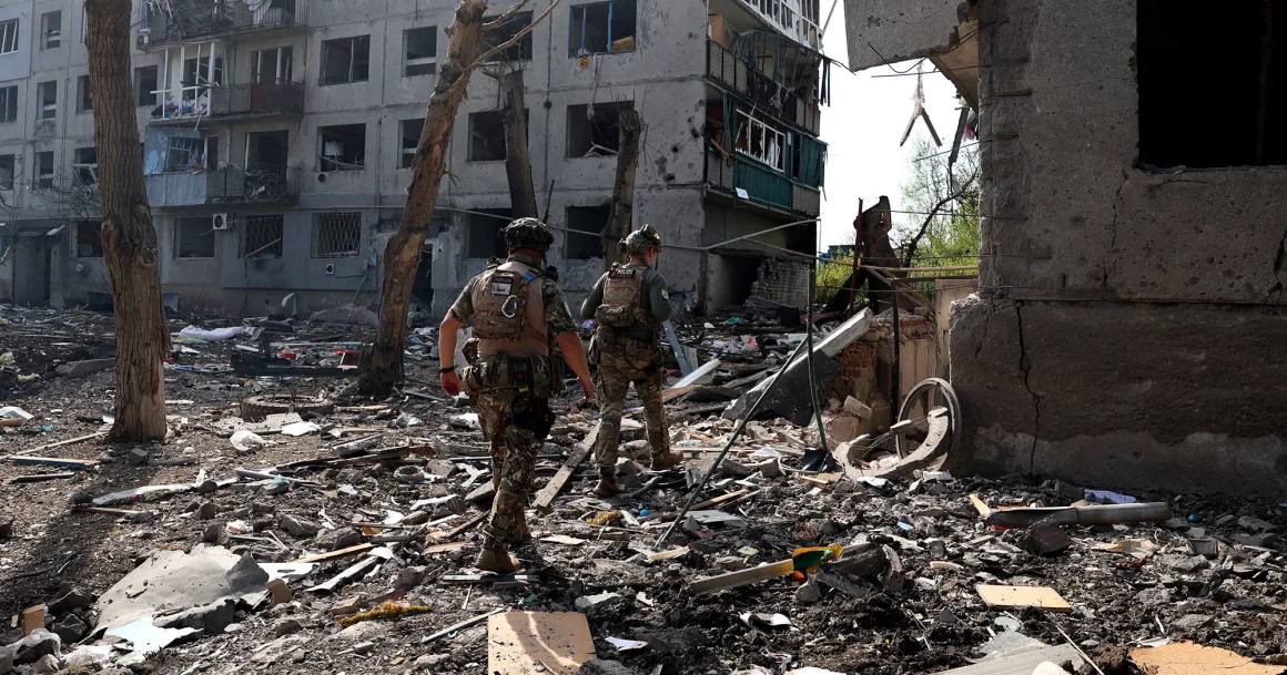 Співробітники спецпідрозділу поліції проходять повз зруйновані будівлі та уламки під час евакуації місцевих мешканців із села Очеретине. 21 квітня 2024 року / Фото AFP