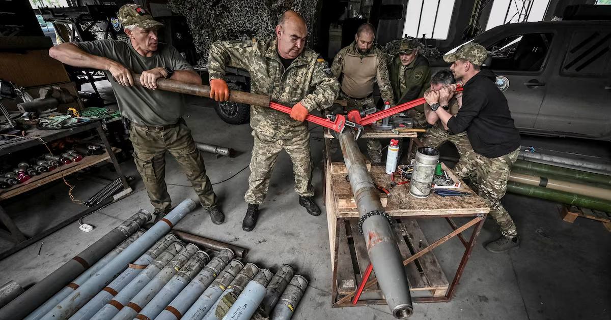 Члены ротной тактической группы "Степные волки" Добровольного формирования Запорожской территориальной громады разбирают снаряд для РСЗО БМ-21 "Град", чтобы переоборудовать его для использования с самодельной малогабаритной РСЗО / Фото Reuters