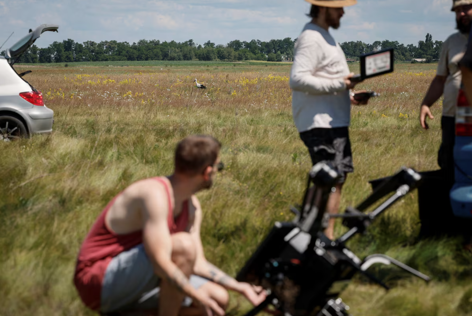 Лелека гуляє по полю, коли фахівці компанії Swarmer готують до польоту дрон зі ШІ / Фото: Reuters