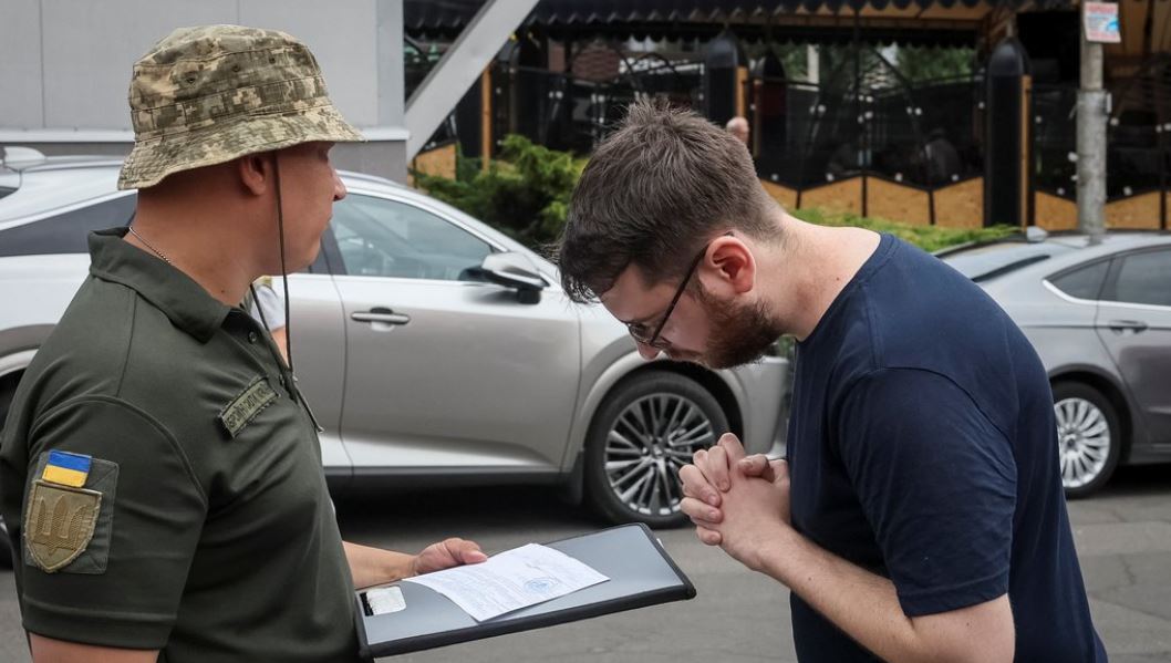 Военнослужащий разговаривает с мужчиной на улице / Фото: REUTERS