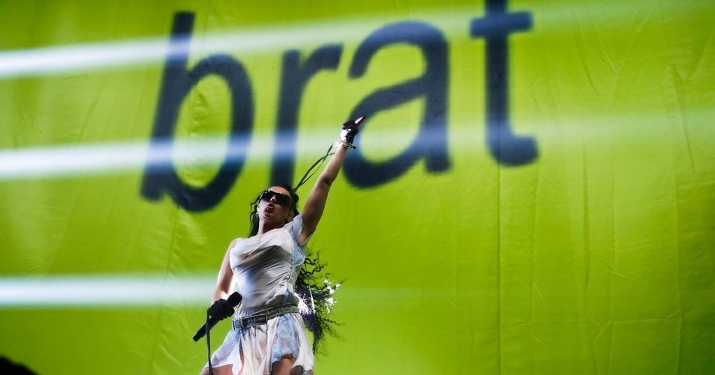 Charli XCX на тлі обкладинки альбому «Brat» / Фото AFP