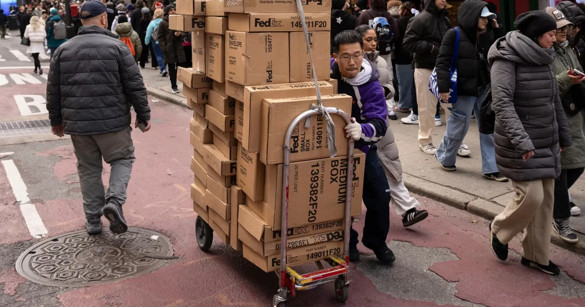 Курьер FedEx перевозит пакеты в «Черную пятницу» в Нью-Йорке, 29 ноября / Фото Bloomberg
