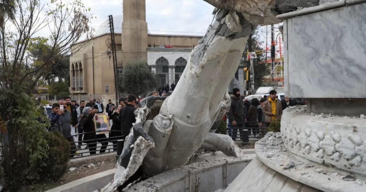 Люди стоят возле поверженной статуи бывшего президента Сирии Хафеза аль-Асада в Камышли, 8 декабря 2024 года / Фото Reuters