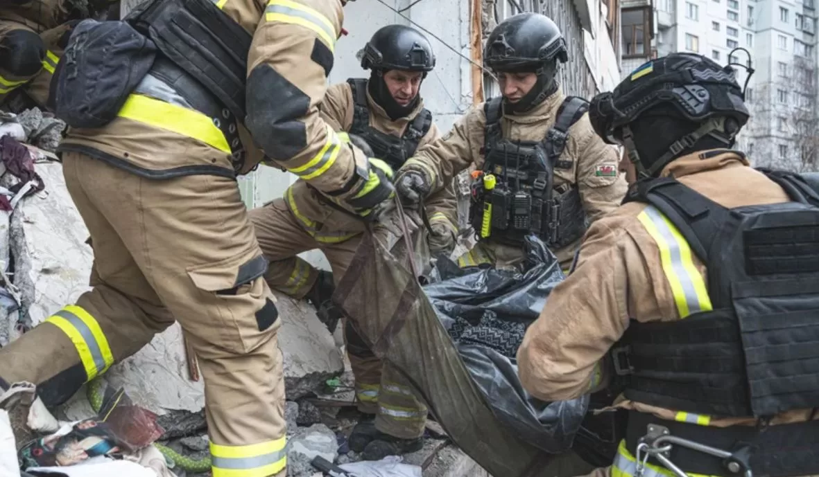 Рятувальники виносять тіло загиблої людини з-під завалів багатоповерхівки у Сумах / Фото: ДСНС