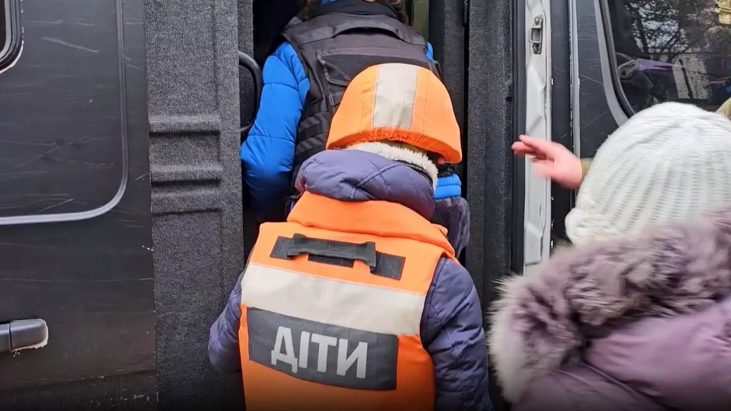 Ребенок садится в эвакуационный транспорт / Скриншот с видео