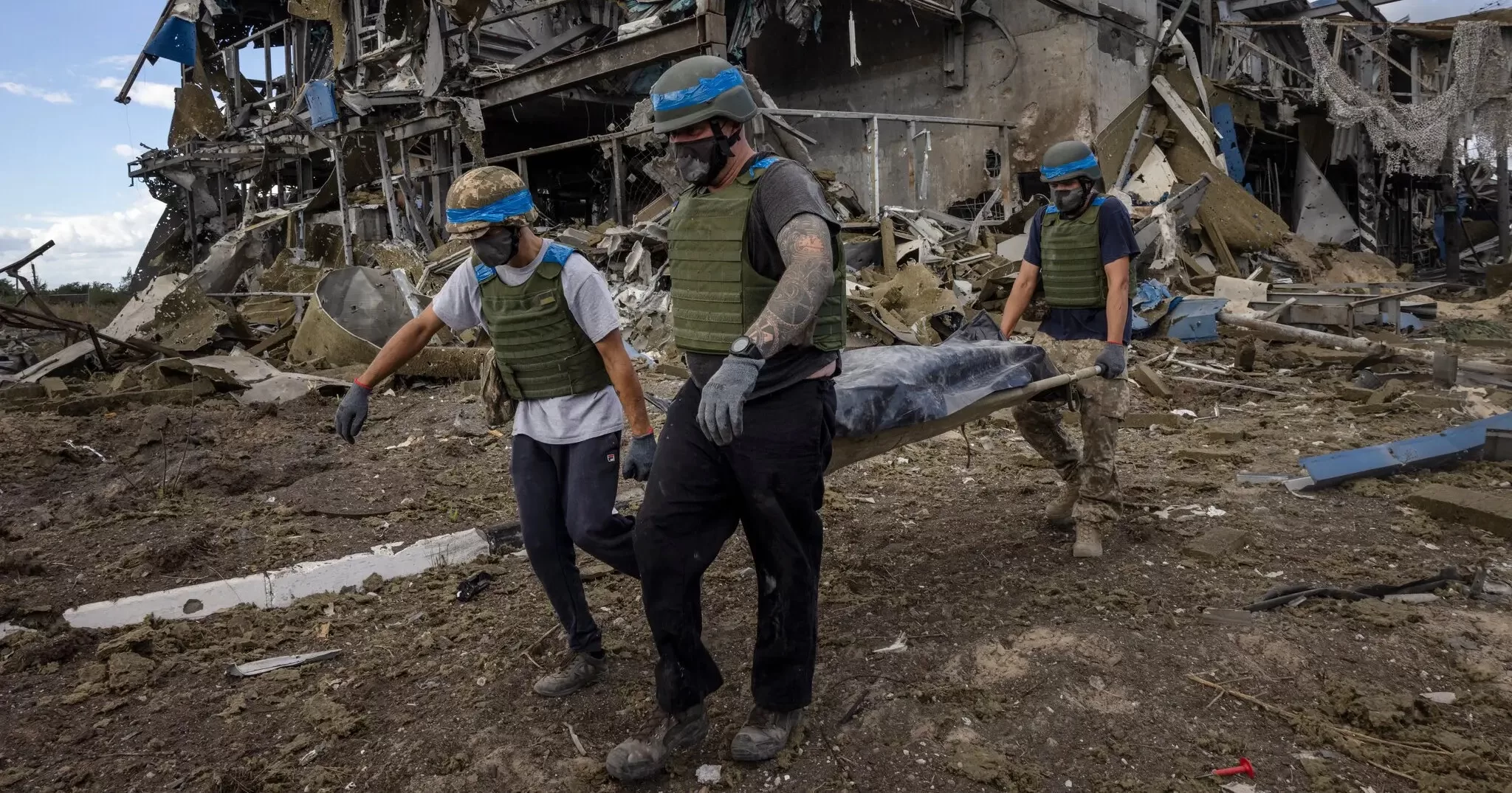 Украинские военнослужащие выносят тело российского солдата из разрушенного здания на пограничном пункте пропуска «Суджа» в августе прошлого года / Фото Дэвида The New York Times