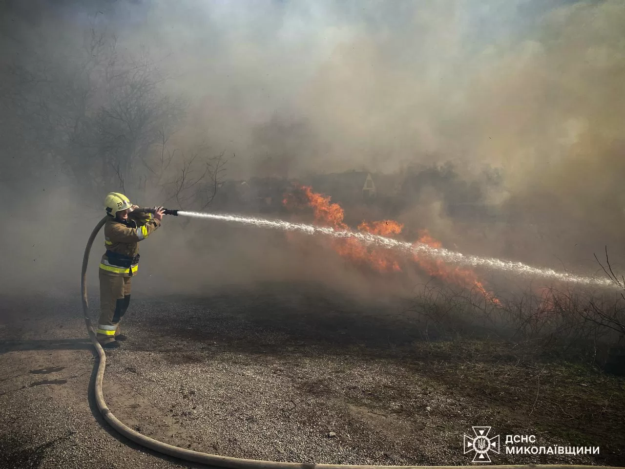 Пожежник гасить траву в полях Миколаївської області / Фото: ДСНС