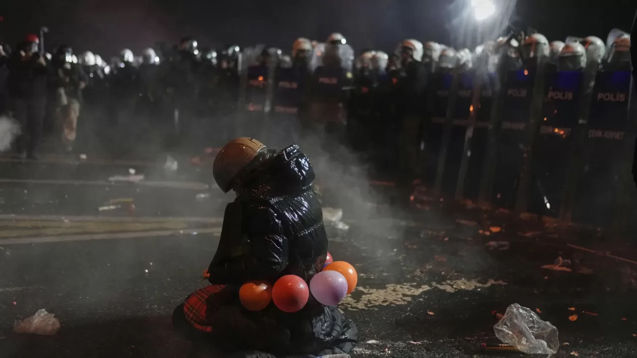 Протестующая сидит на коленях перед спецназовцами во время акции протеста против ареста мэра Стамбула Экрема Имамоглу, в Стамбуле, суббота, 22 марта 2025 года / Фото AP Photo