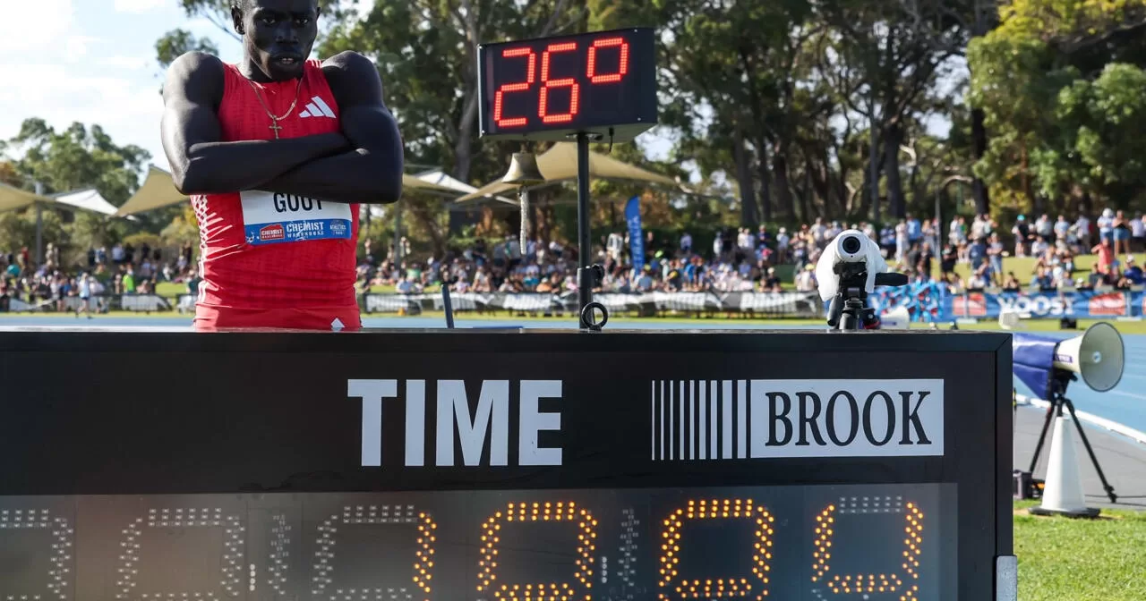 Гоут Гоут позує поруч зі своїм результатом 19,84 після перемоги у фіналі чоловічого забігу на 200 метрів під час чемпіонату Австралії з легкої атлетики / Фото AFP