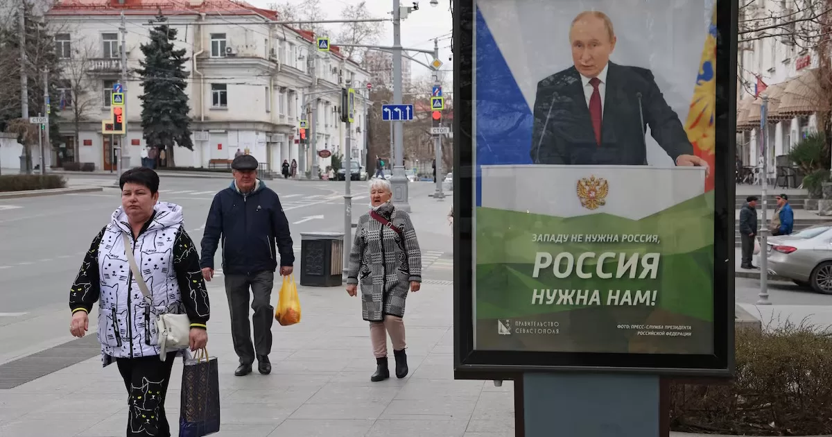 Люди проходят мимо баннера с изображением президента Путина в оккупированном Севастополе, 22 марта 2025 года. На баннере написано «Западу не нужна Россия, нам нужна Россия!» / Фото Reuters