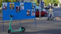 Жінка їде на самокаті повз передвиборчі плакати перед президентськими виборами в Румунії, Бухарест, 29 квітня 2025 року / Фото Reuters