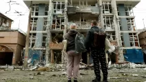 Жители смотрят на жилой дом в Киеве, поврежденный в результате удара российского беспилотника 25 мая 2025 года / Фото Reuters