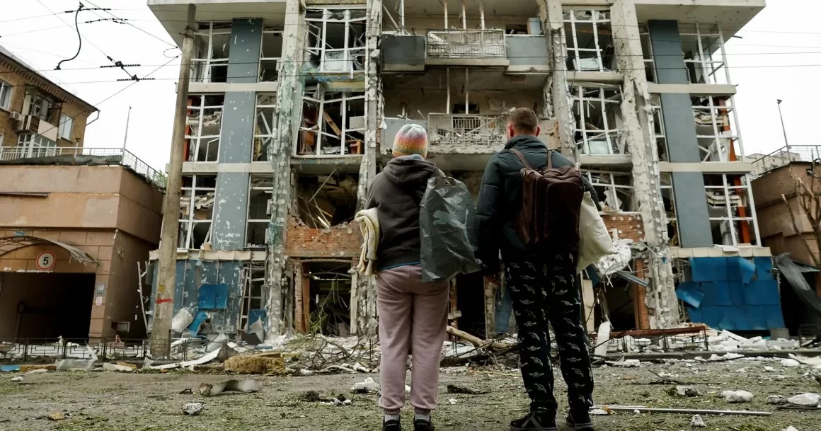 Жители смотрят на жилой дом в Киеве, поврежденный в результате удара российского беспилотника 25 мая 2025 года / Фото Reuters