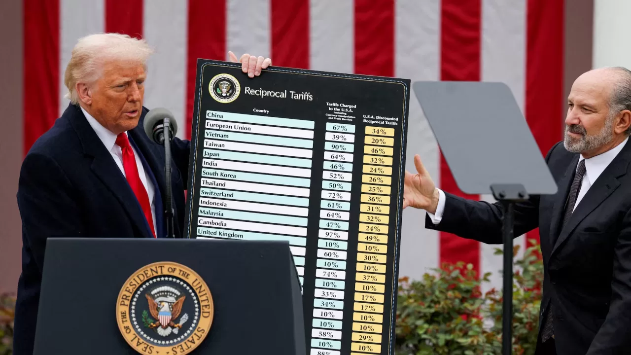 Дональд Трамп тримає і міністр торгівлі США Говард Лутнік під час виступу щодо мит у Рожевому саду Білого дому у Вашингтоні, 2 квітня 2025 / Фото Reuters