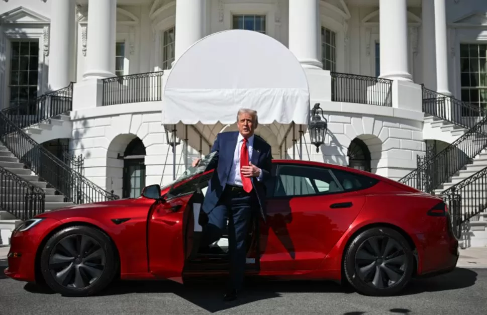 Президент США Дональд Трамп вылезает из красной Tesla S / Фото: AP