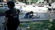 Женщина склонилась над телом родственника, погибшего в результате российского удара по Сумам, 3 июня 2025 года / Фото AP