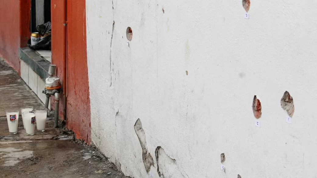 Свічки-обітниці стоять біля будинку, пошкодженого кулями, в результаті стрілянини / Фото: REUTERS