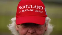 Мужчина в аэропорту Прествик перед прибытием президента США в Глазго. Надпись на бейсболке: «Шотландия уже великая» / Фото EPA