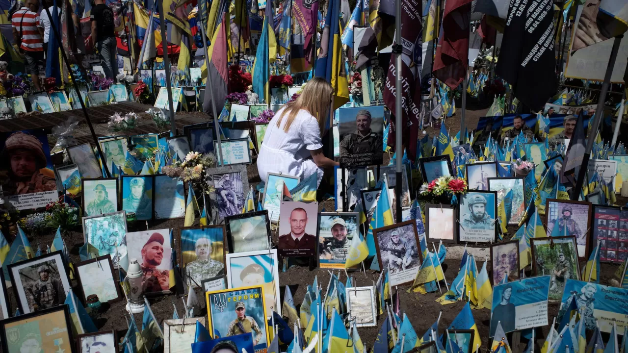 Жінка віддає шану пам'яті загиблим солдатам на Майдані Незалежності в Києві, 9 серпня 2025 / Фото Reuters