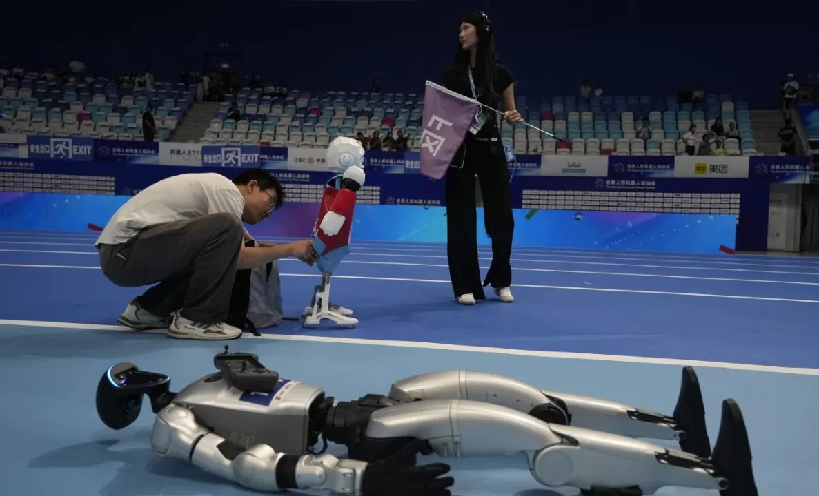 Робітник готує робота до церемонії відкриття Всесвітніх ігор гуманоїдних роботів / Фото: AP