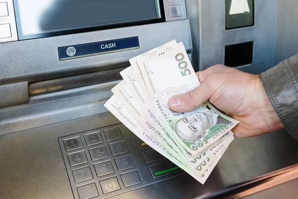Людина знімає гроші у банкоматі / Фото ілюстративне: Depositphotos