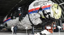 Юристи оглядають реконструйований корпус літака рейсу MH17 авіакомпанії Malaysia Airlines на авіабазі Гільзе-Рейєн у Нідерландах. 26 травня 2021 / Фото Reuters