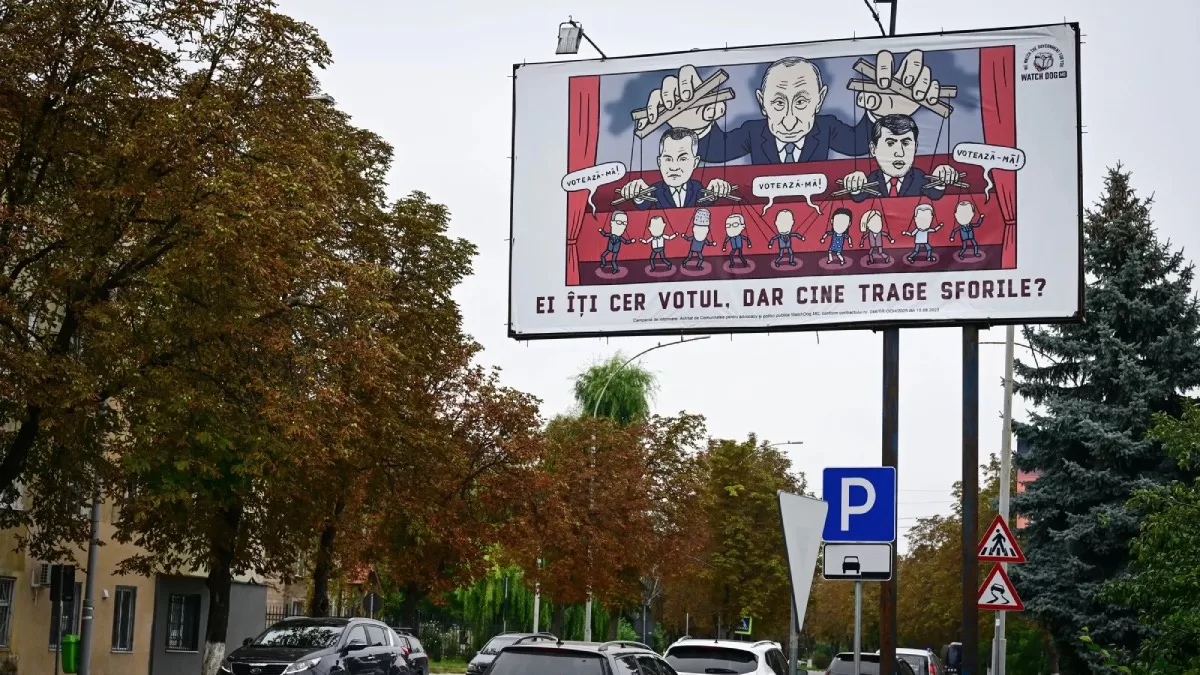 Билборд в Унгенах, Молдова, изображает карикатуру на Владимира Путина, который дергает за ниточки кандидатов в предстоящих выборах страны / Фото AFP