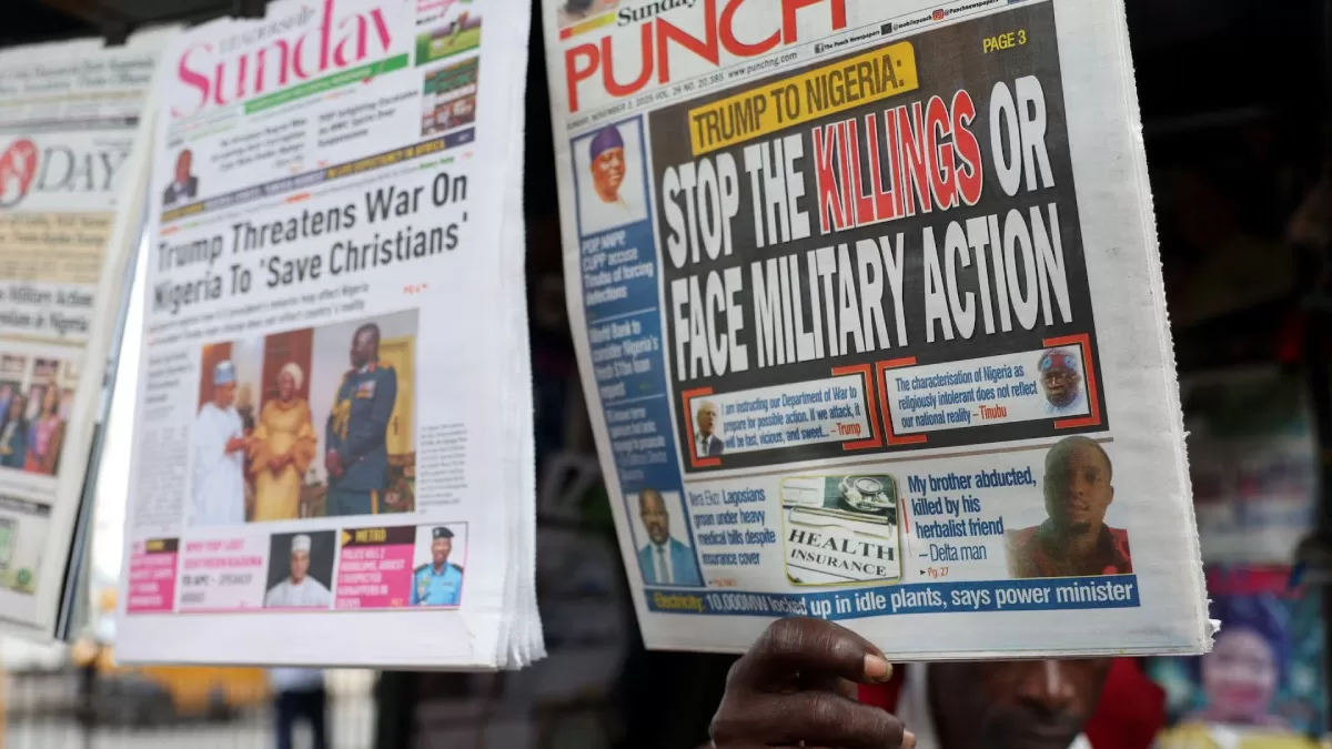 Продавец показывает газету со статьей, в которой сообщается об обращении президента США Дональда Трампа к Нигерии относительно отношения к христианам, Лагос, Нигерия, 2 ноября 2025 года / Фото Reuters