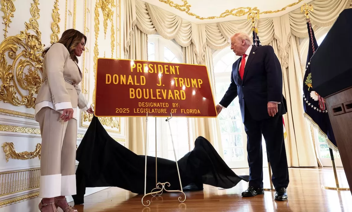 Президент США Дональд Трамп и член Палаты представителей Флориды Мэг Вайнбергер открывают дорожный знак на церемонии, посвященной присвоению 4-мильному участку дороги от аэропорта Вест-Палм-Бич до поместья Трампа «Мар-а-Лаго» / Фото: REUTERS/Кевин Ламарк