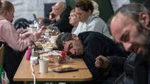 Люди пьют горячие напитки, наверстывают сон и заряжают устройства в «пунктах несокрушимости» / Фото EPA