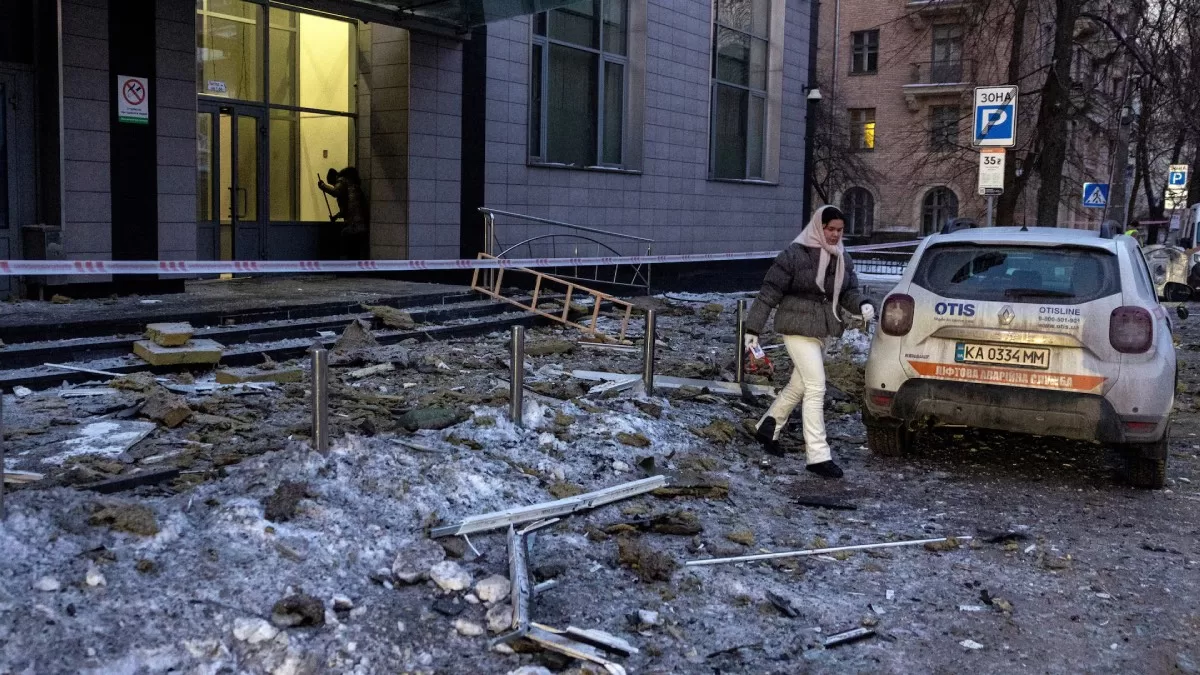 Жінка йде по уламках біля житлового будинку, який був уражений безпілотником під час російських ракетних і безпілотних атак у Києві, 3 лютого 2026 року / Фото Reuters