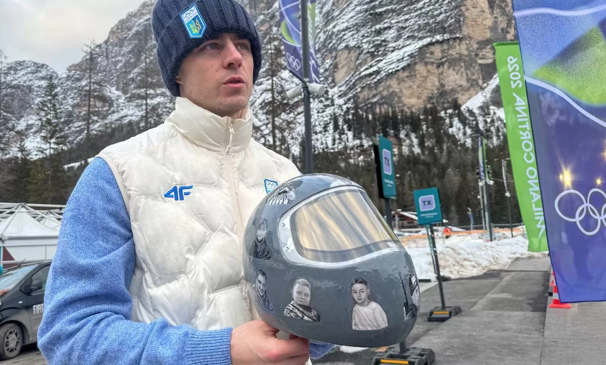 Украинский скелетонист Владислав Гераскевич держит шлем с изображениями соотечественников, погибших во время войны в Украине, Италия, 9 февраля 2026 года / Фото: REUTERS