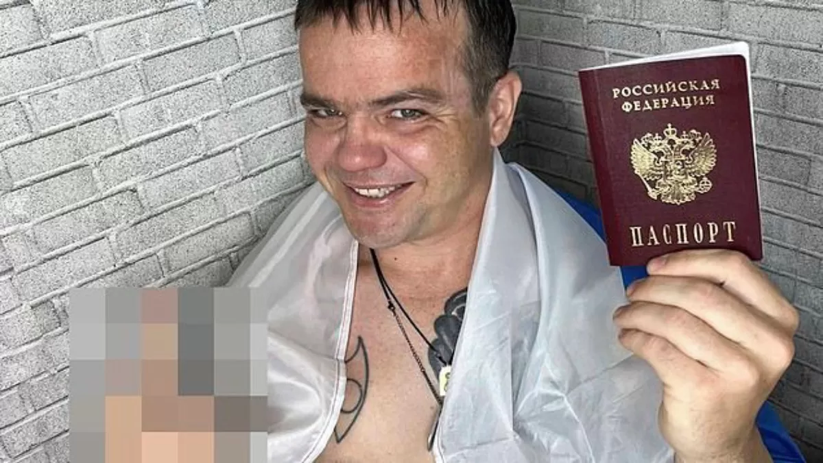 Эйден Миннис держит в руке российский паспорт / Фото из соцсетей