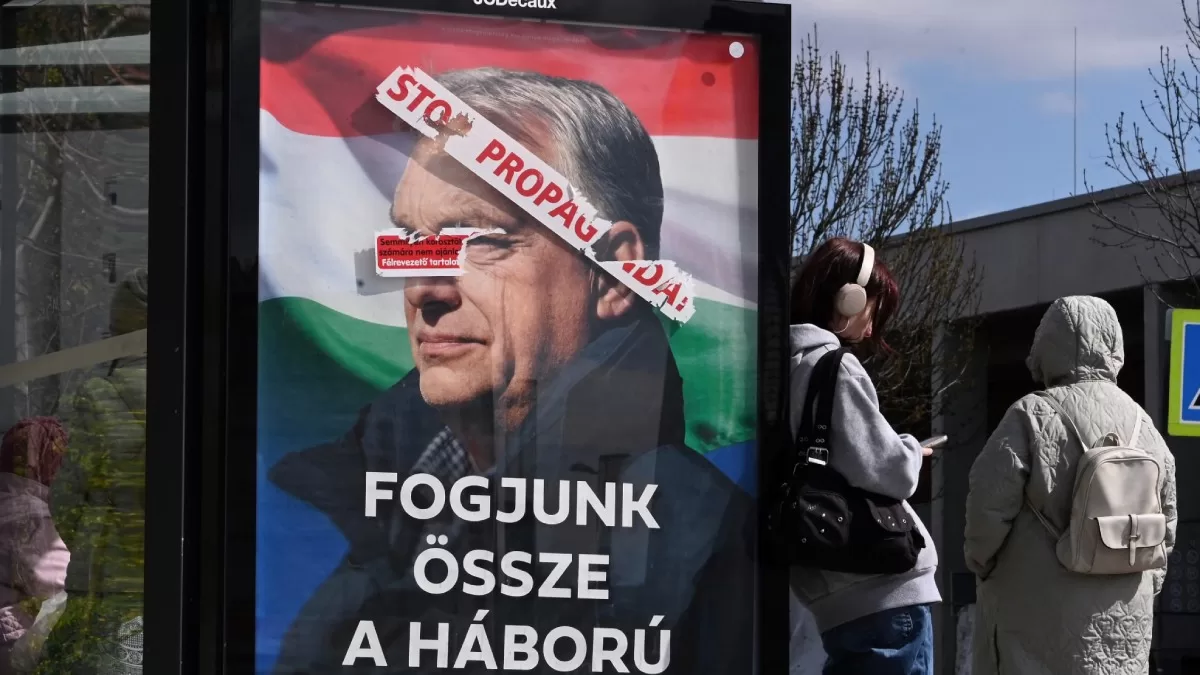 На плакате к всеобщим выборам в 3-м районе Будапешта изображён премьер-министр Венгрии Виктор Орбан, а под ним размещены надписи: «Прекратите пропаганду» (сверху) и «Объединимся против войны» (снизу) / Фото AFP