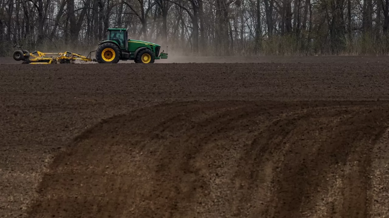 6 апреля 2026 года в селе Малополовецкое Киевской области, на фоне российского вторжения в Украину, сельхозработник управляет трактором, готовя почву к посеву гречихи / Фото: REUTERS