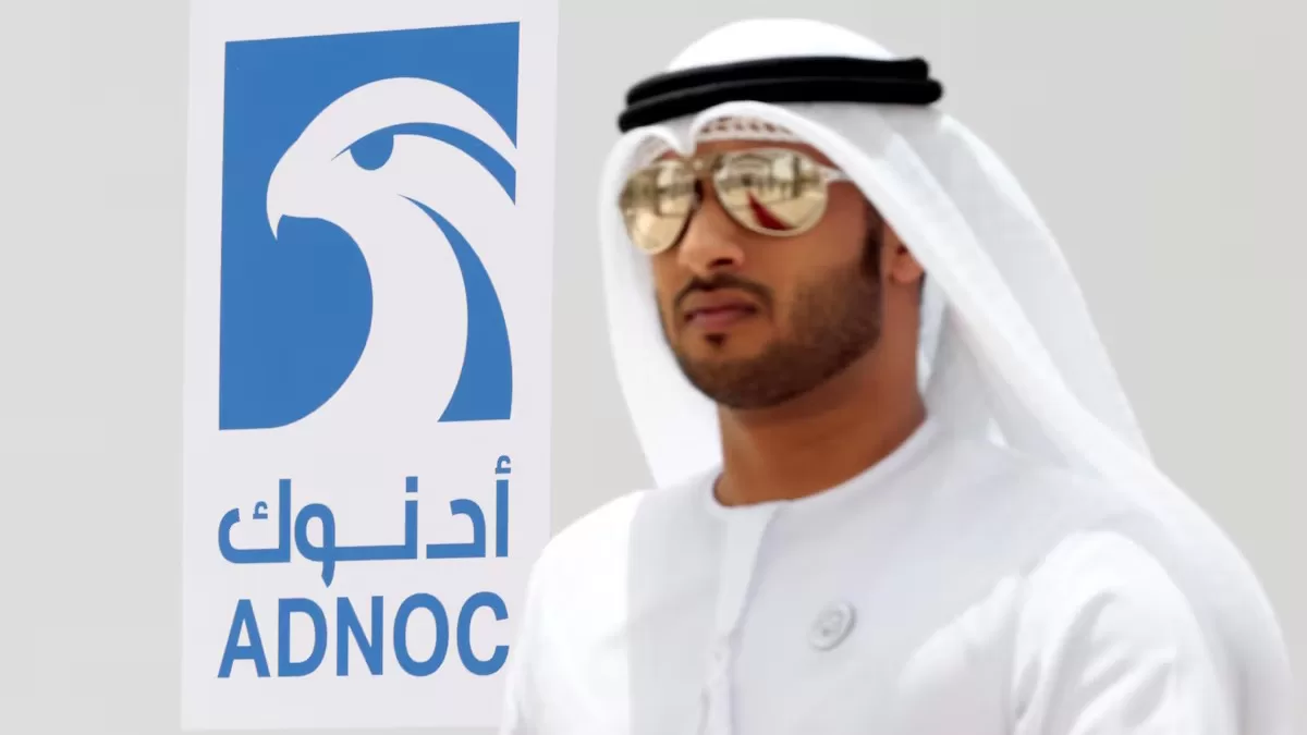 Мужчина из ОАЭ возле логотипа компании ADNOC в городе Рувайс, Объединённые Арабские Эмираты, 14 мая 2018 года / Фото Reuters