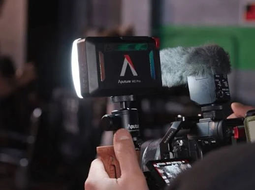 Компактна RGB-панель серії Aputure MC на камері з мікрофоном-пушкою під час зйомки