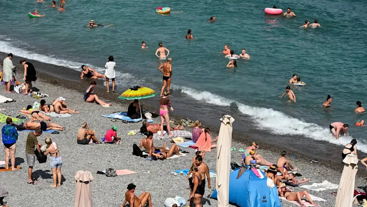 Люди засмагають на пляжі в чорноморському курорті Ялта / Фото: AFP