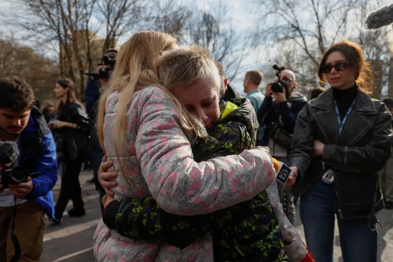 Українка обіймає 13-річного сина після його повернення з Росії / Фото: Reuters