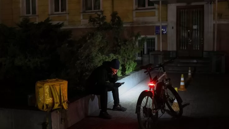 Кур’єр під час відключення світла в Києві / Фото: Reuters