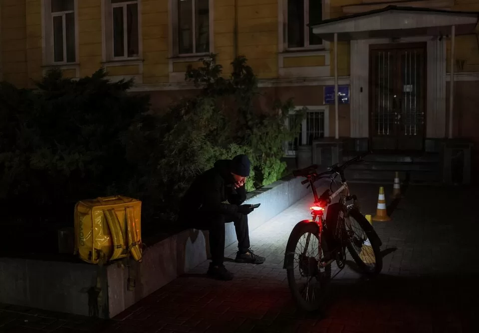 Кур’єр під час відключення світла в Києві / Фото: Reuters