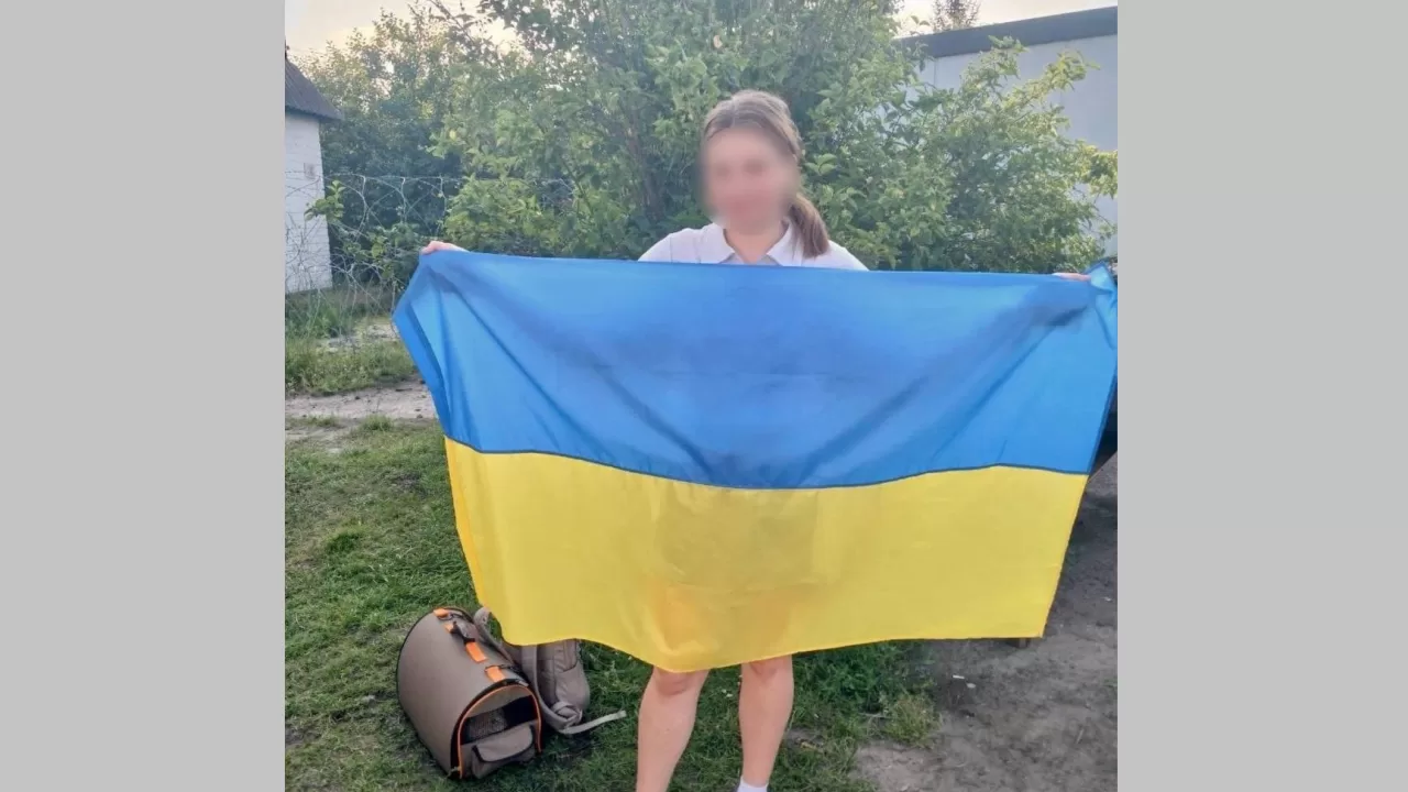 Одна з українок, яка повернулася з тимчасово окупованої території, з державним прапором України / Фото: Офіс Омбудсмана України